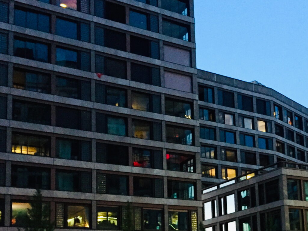 The façade of an office block with grid-patterned windows at dusk
